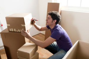 man labeling his moving boxes